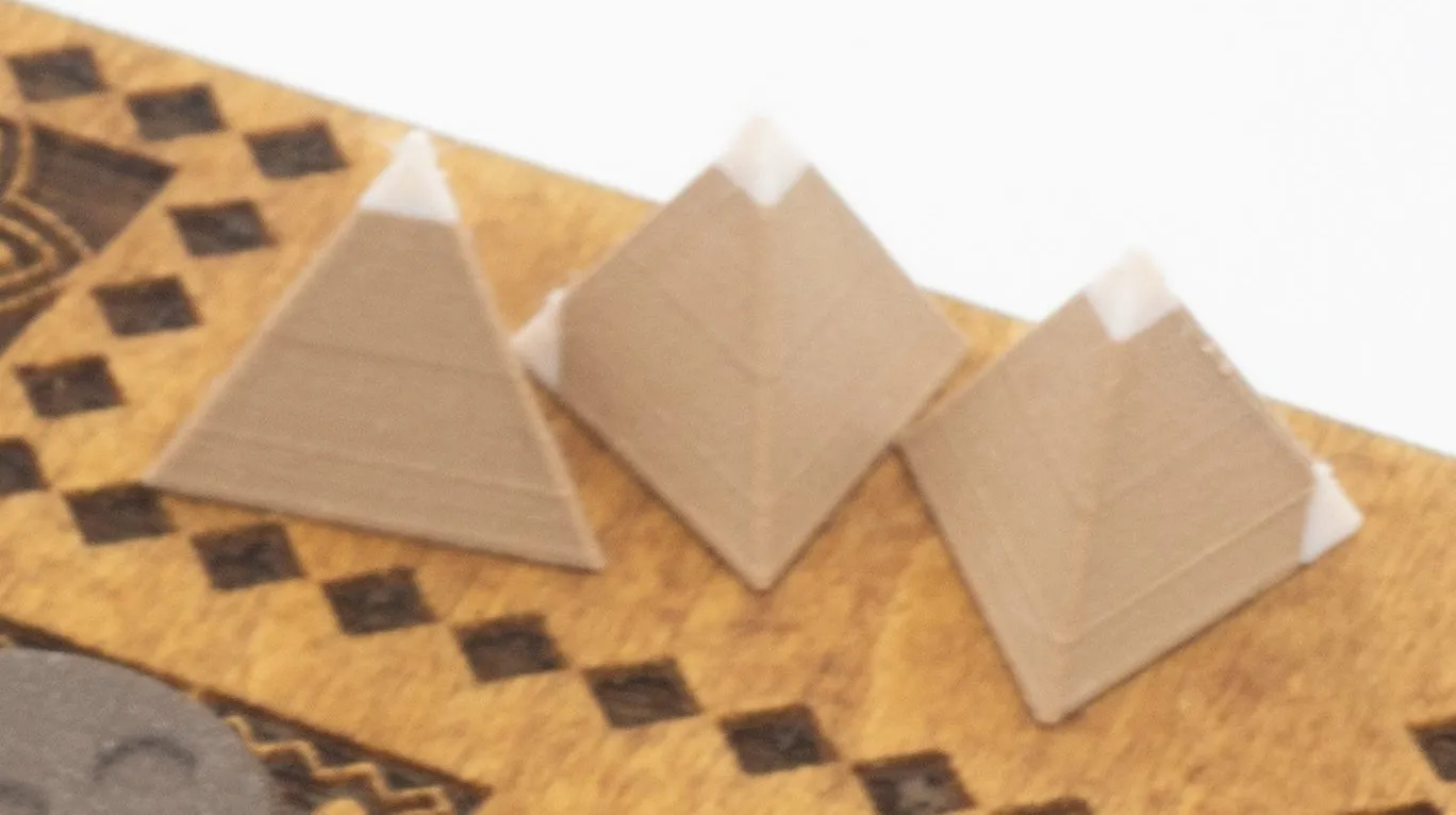 Close-up of the tetrahedral dice. Two corners of each die are tipped in white, and those tips are what you count.